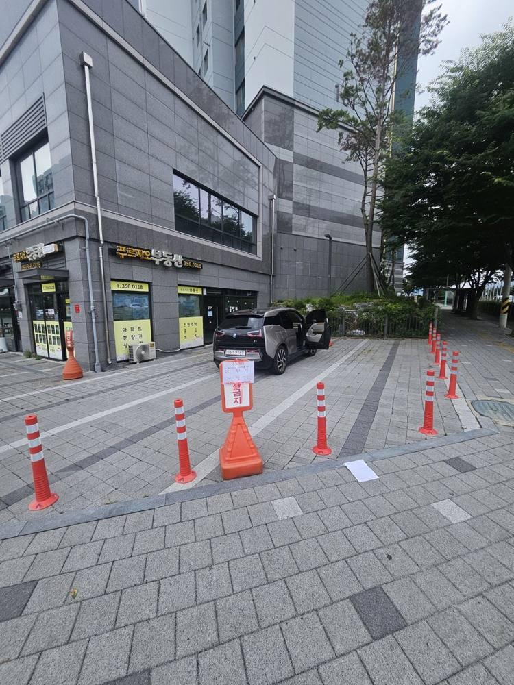 상가 앞 보도에 줄지어 설치한 주황 차선규제봉